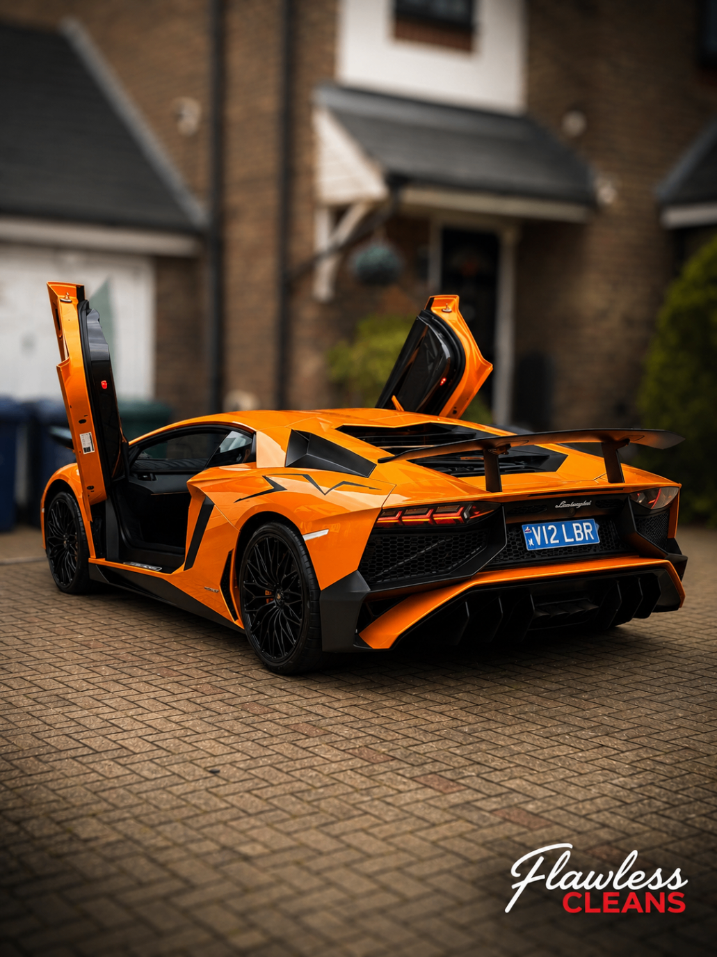 Orange Lamborghini Aventador SV with scissor doors raised on a driveway