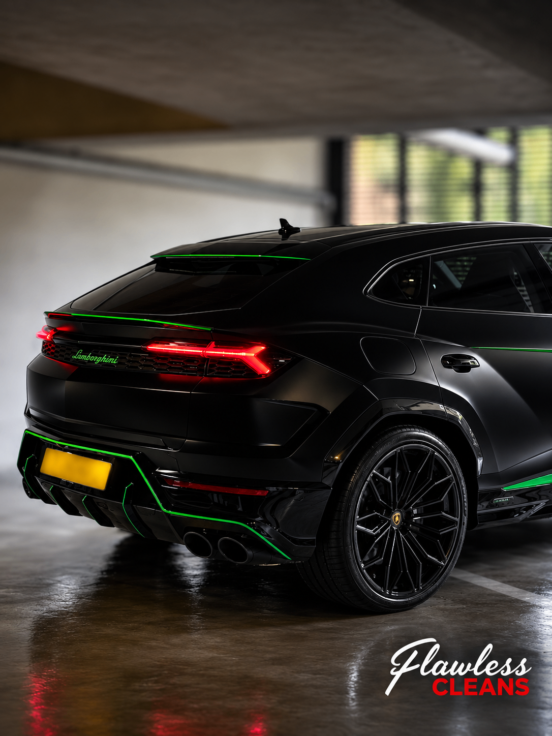 Black Lamborghini Urus with green accents detailed in a parking structure