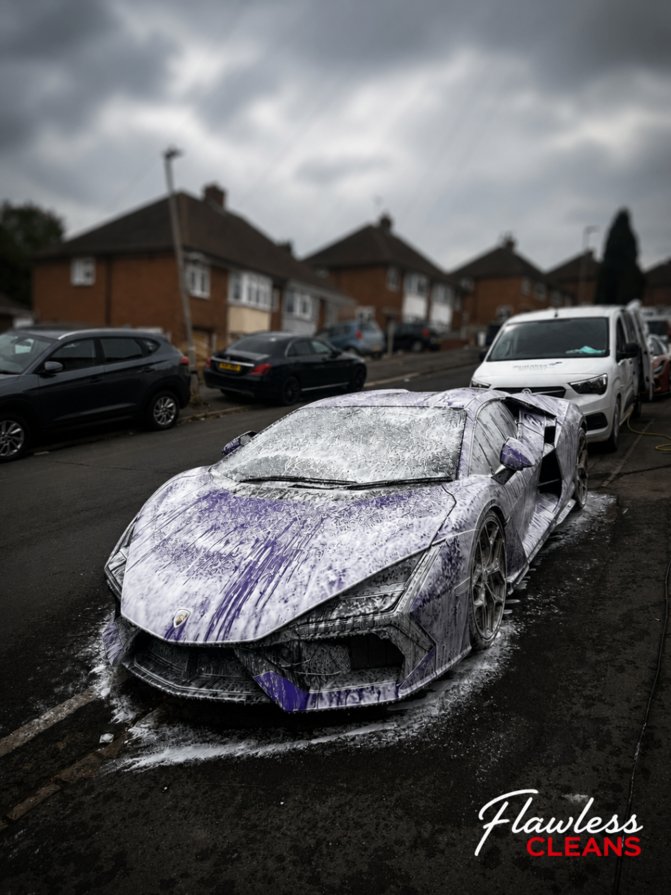 Lamborghini Revuelto covered in purple snow foam during a pre-wash